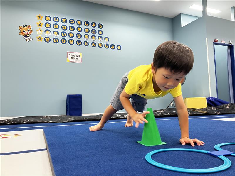 プランクの体勢から右手を床から離している男の子