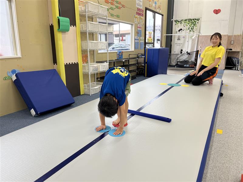 前転の手の位置を練習する子どもの様子