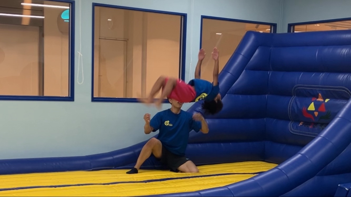 トランポリンを使いバク宙をする男の子の様子