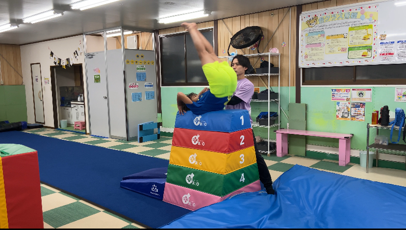 跳び箱の上で伸膝台上前転をするこどもの様子