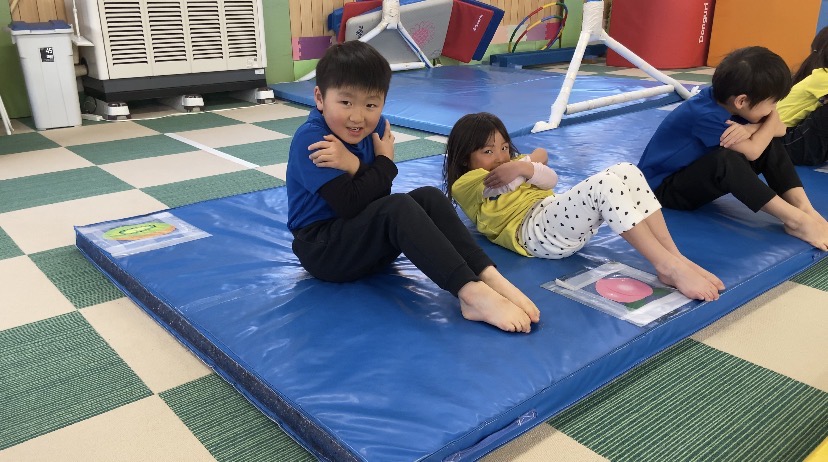 マットの上で上体起こしをする子どもたちの様子