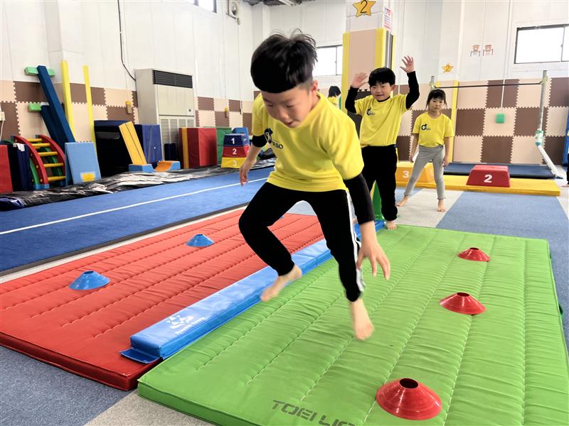 低い姿勢ですばやく左右に動く練習をする子どもたちの様子