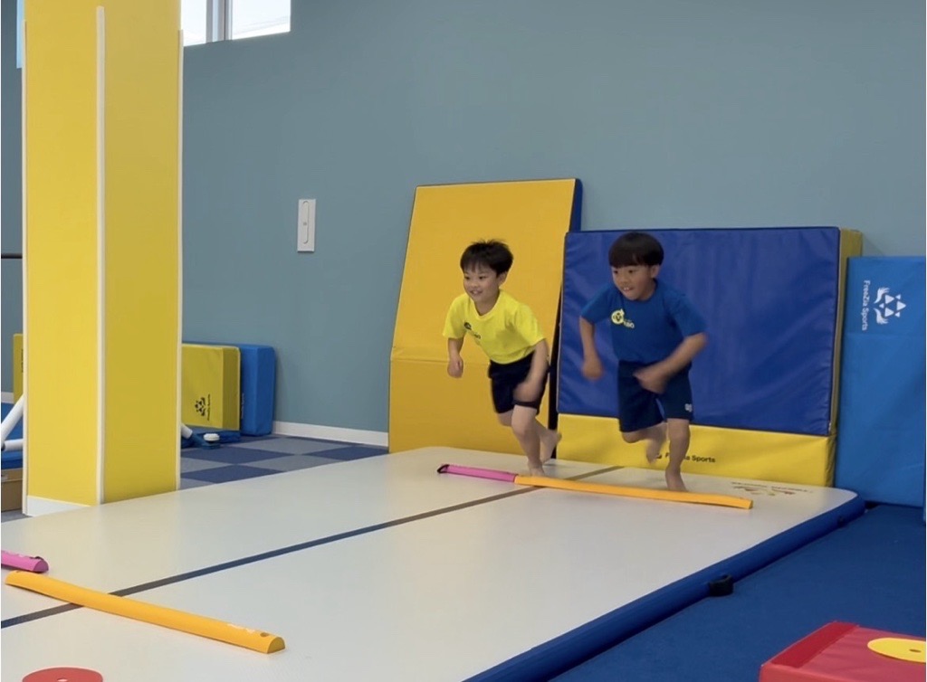 前傾姿勢で印に足をそろえシャトルランのスタートを切る子供たちの様子